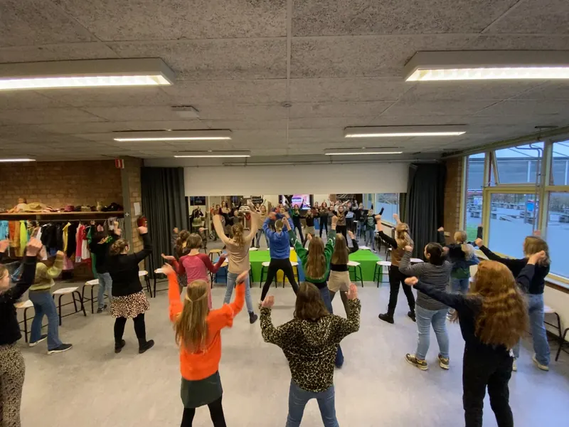 Leerlingen bewegen en beelden samen iets uit in de aula