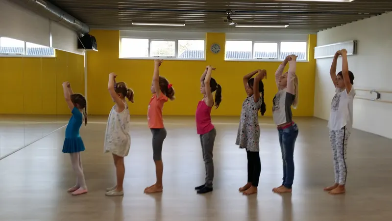 Kinderen maken samen een handstand tegen de muur